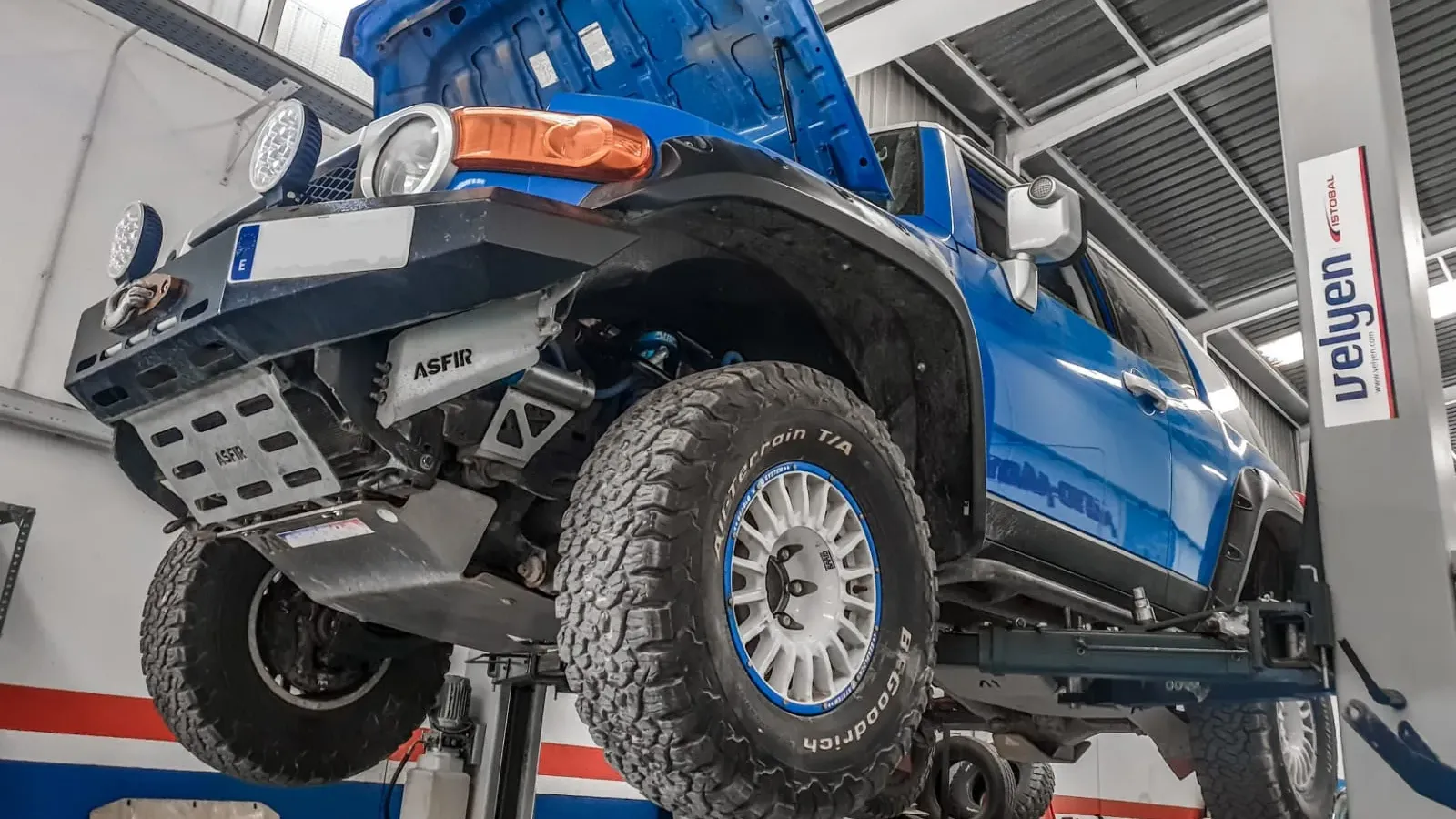 Toyota FJ Cruiser subido en el elevador de dos columnas del taller