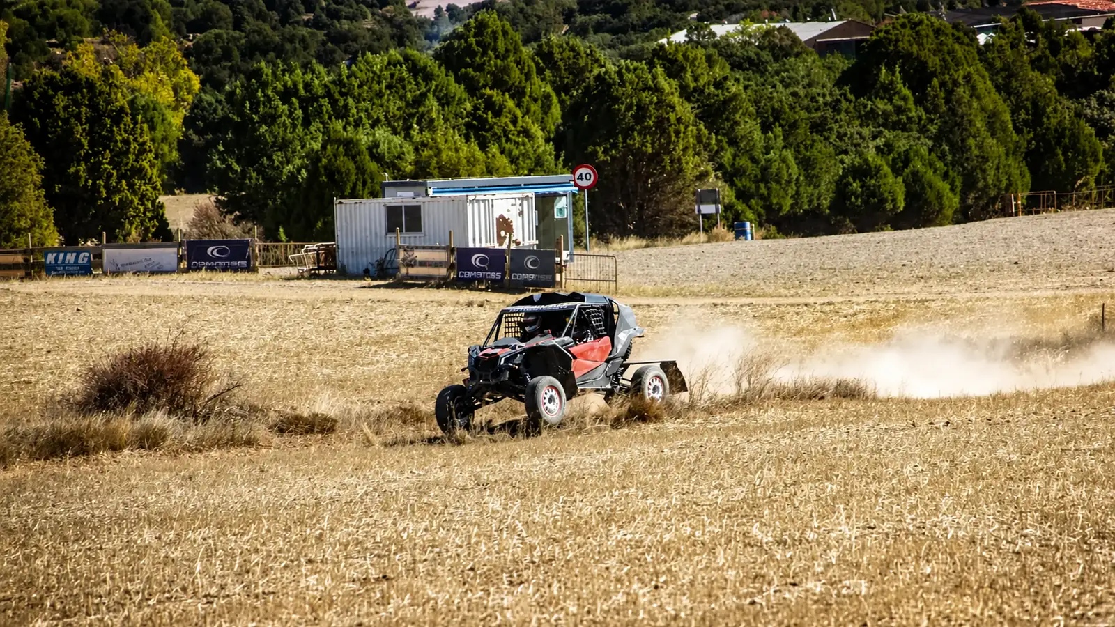 Prototipo de competición del equipo de Automotor 4x4 corriendo por el campo y levantando polvo
