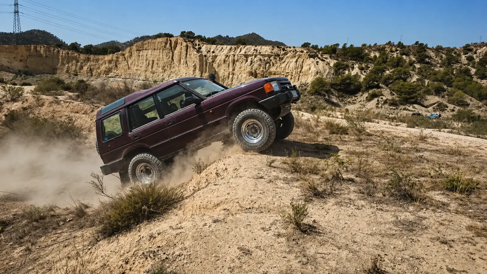 Land Rover Discovery 300 Tdi subiendo por una pista de tierra entre cárcavas y levantando polvo